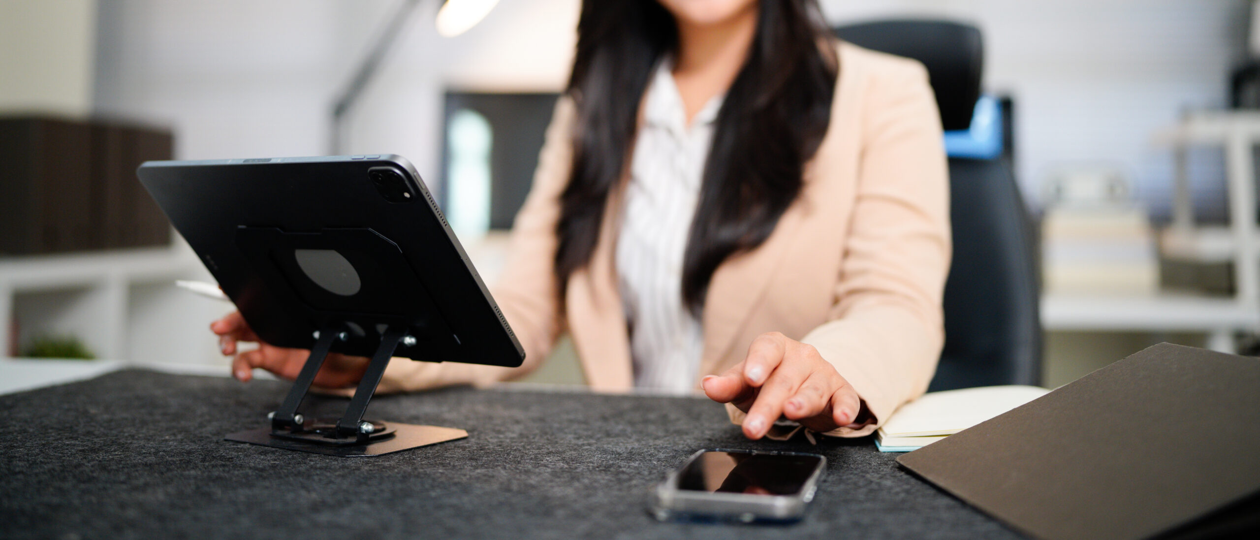 Hand einer Frau bedient Tablet und Smartphone