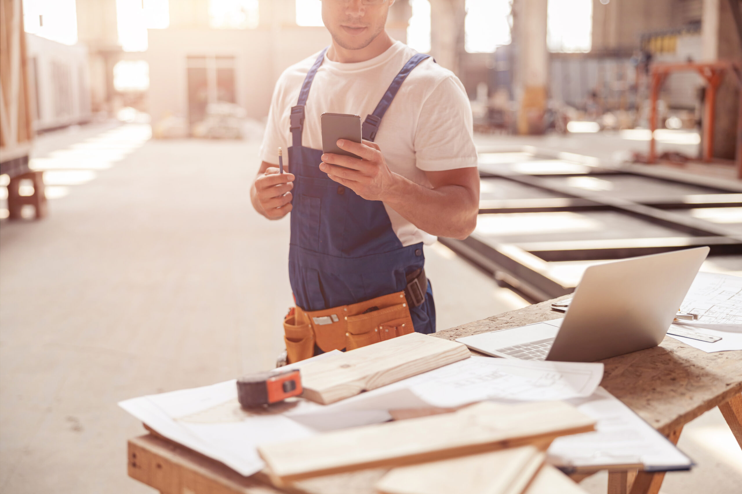 Tischler hält Smartphone